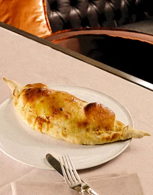 A golden Calzone Dolce served on a white plate at Park Hotel.
